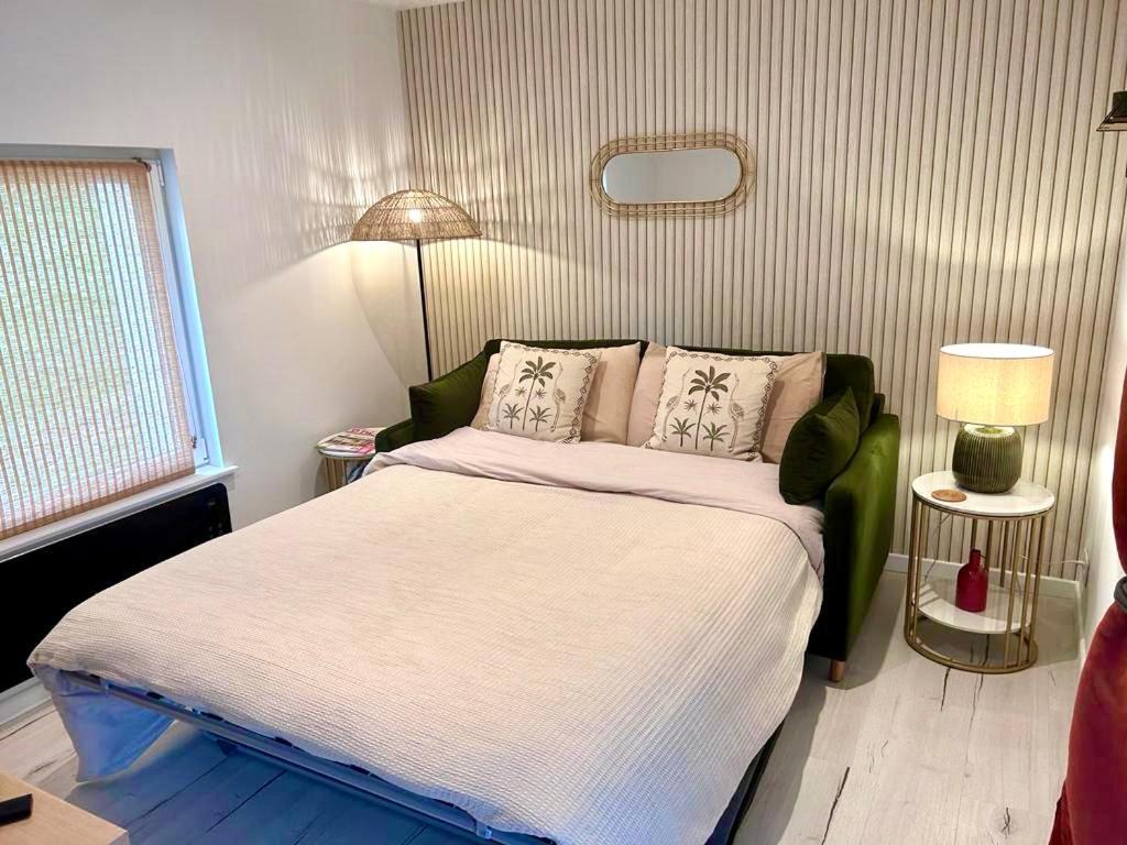 een slaapkamer met een groot bed in een kamer bij Le Cocoon de la Héronnière in Houlle