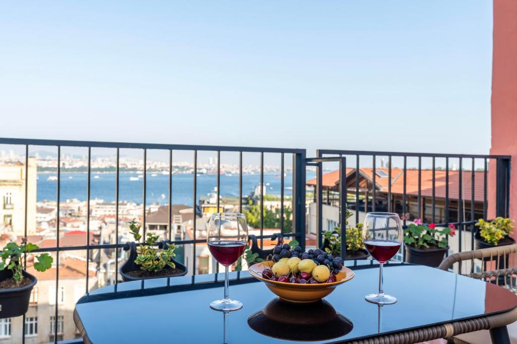 een tafel met twee glazen wijn en een fruitschaal bij Atlas Han Hotel in Istanbul