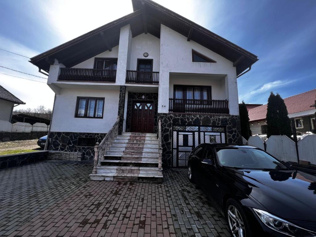 a black car parked in front of a house at Casa Maramureșanului in Sighetu Marmaţiei