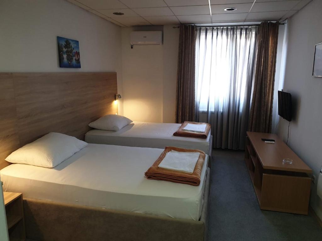 a hotel room with two beds and a desk at Magic Apartments 2 in Ub