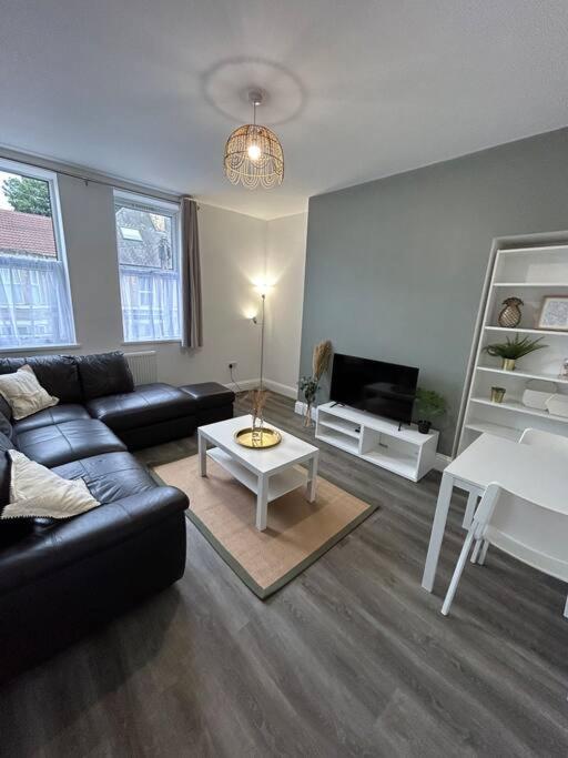 een woonkamer met een bank en een tafel bij Stylish 1 bed apartment in Hull