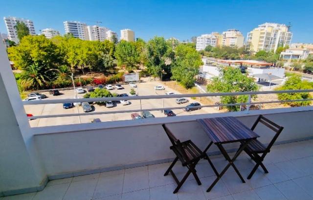 2 sillas en un balcón con vistas a un aparcamiento en Sofiamarholidays- Casa levante, en Portimão