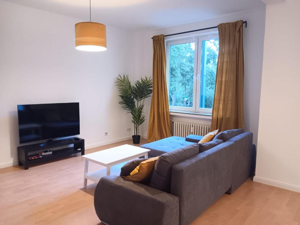 a living room with a couch and a window at Spacious 70sqm apt in popular location in Düsseldorf