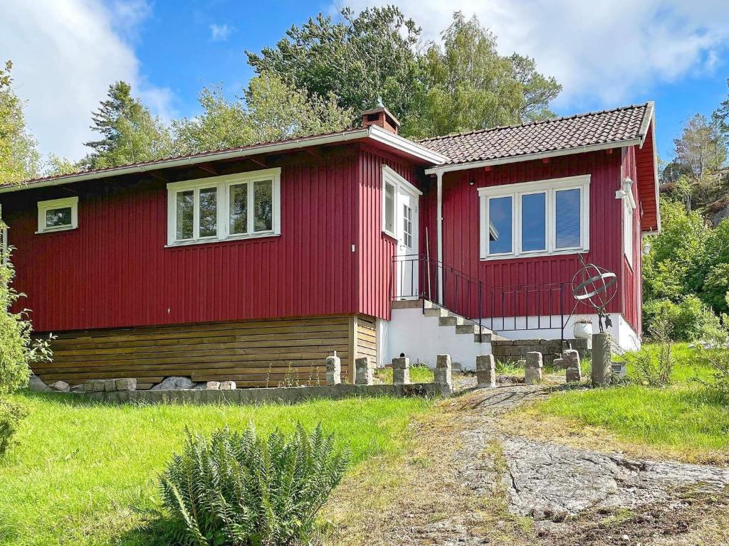 una casa roja y blanca en un campo en Holiday home UDDEVALLA XL en Sundsandvik