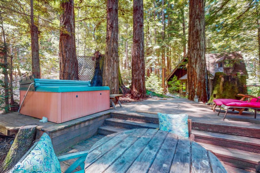 un tavolo e sedie su una terrazza in legno con alberi di Dreamcatcher Cottage a Cazadero