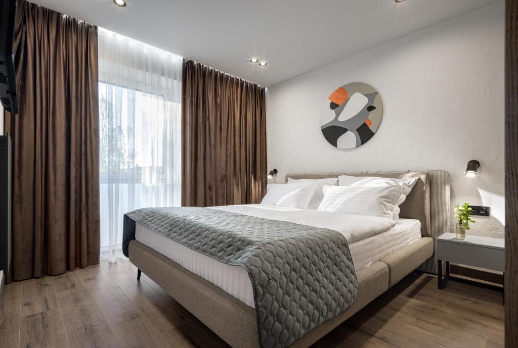 um quarto com uma cama grande e uma janela grande em Apartel Uzhhorod em Uzhhorod