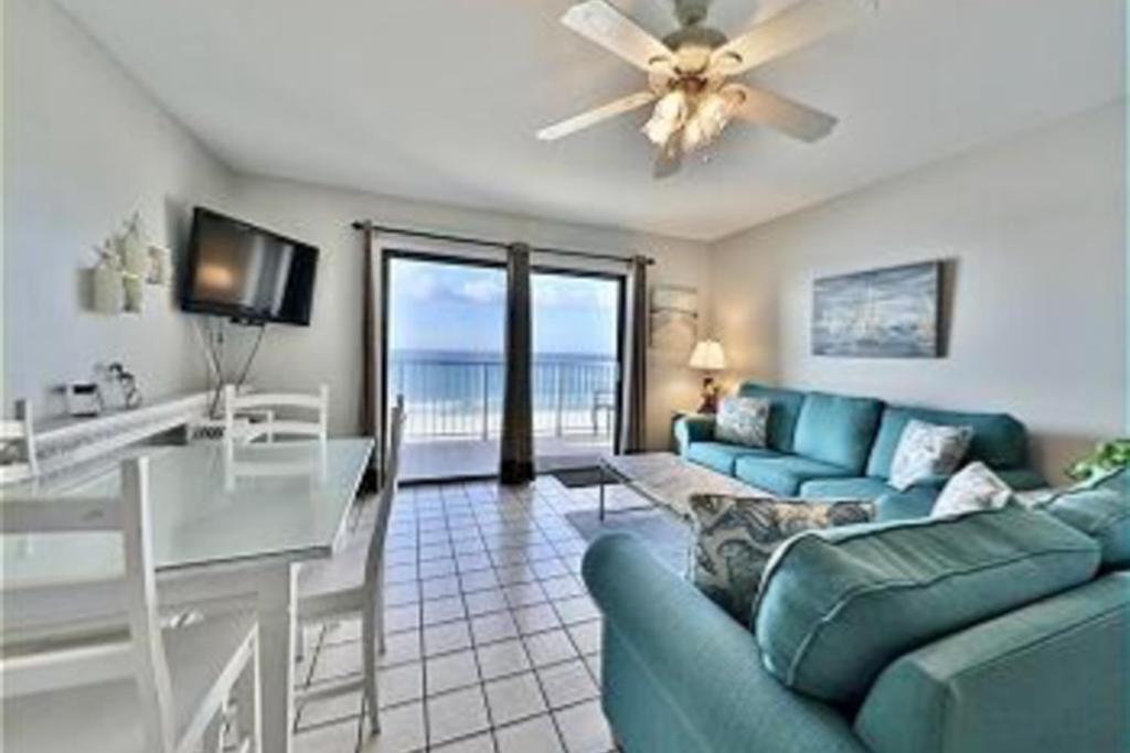 uma sala de estar com um sofá azul e uma mesa em Summit 723 em Panama City Beach