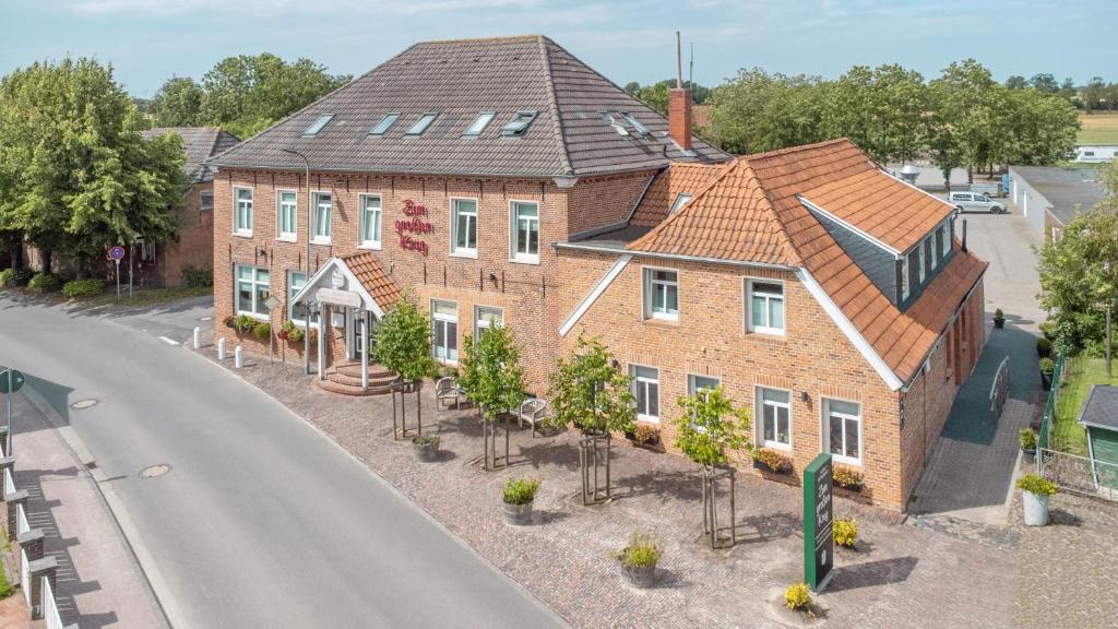 una vista aérea de una casa con árboles frente a una calle en Hotel Zum Großen Krug en Wirdum