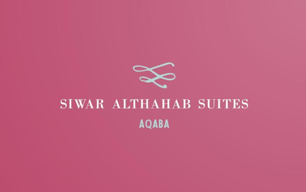 różowe tło z nożyczkami w obiekcie Siwar Al-Thahab Suites & Hotel Apartments w Akabie