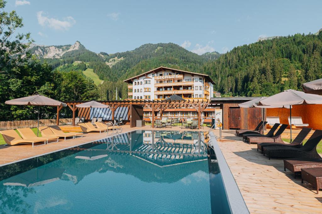 ein Hotel mit einem Pool mit Bergen im Hintergrund in der Unterkunft Lechlife Apartments inkl Spabereich - 400m zum Lift in Reutte