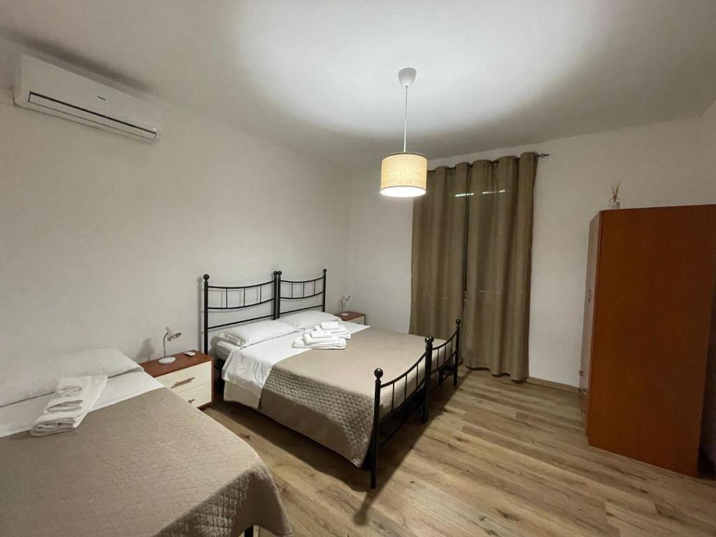 una camera con 2 letti singoli e una lampada di Affittacamere La Filigrana (Ospedale) a Fabriano
