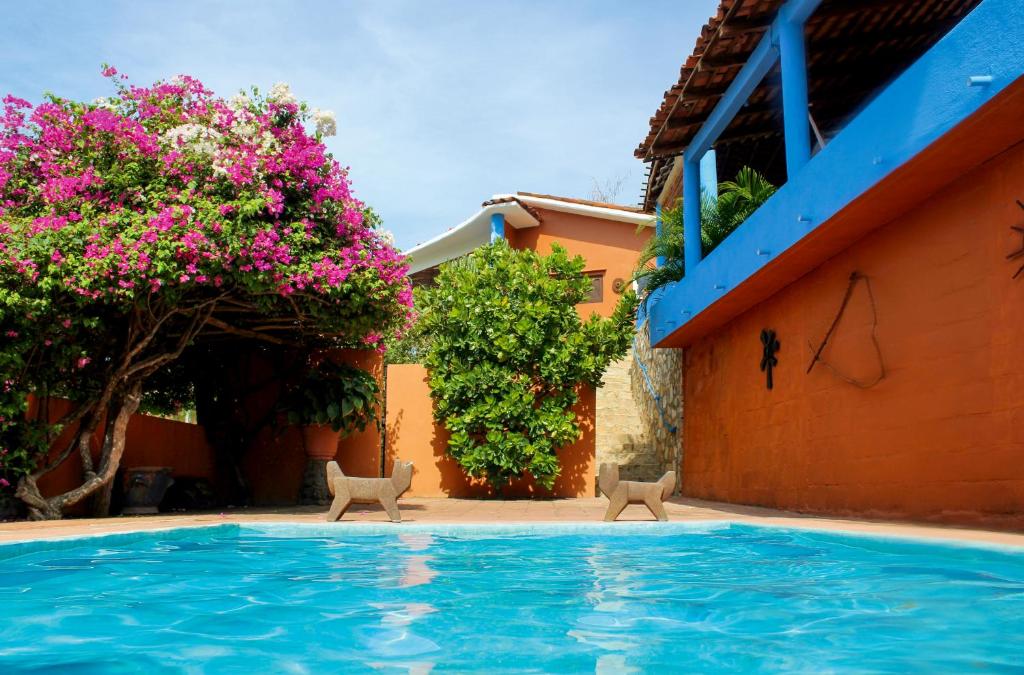 a swimming pool in front of a house with flowers at Casa Azul in San Agustinillo