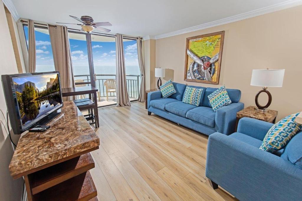 sala de estar con sofá azul y TV en 14Th Floor Condo with Amazing Views, en Myrtle Beach
