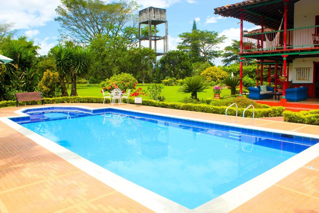 una grande piscina in un cortile con una casa di Casa Abbá Hotel a La Tebaida