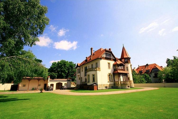 a large house with a large yard with green grass at PAŁACYK BUDGET in Legnica