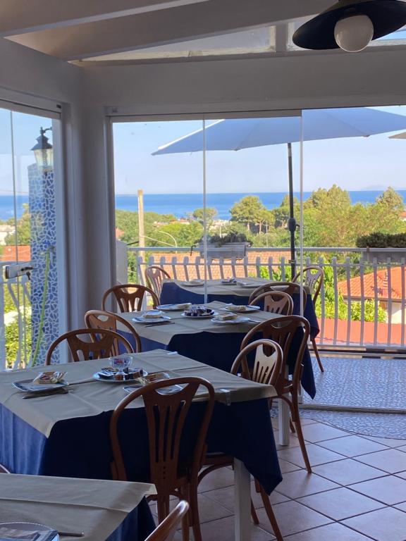 um restaurante com mesas e cadeiras com vista para o oceano em Hotel Ristorante Colleverde em Santa Maria di Castellabate