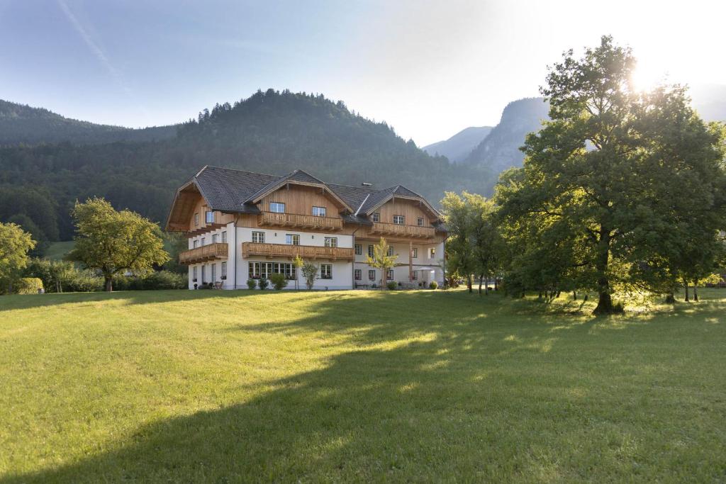 une grande maison sur un champ herbeux dans les montagnes dans l'établissement Branntweinhäusl, à Sankt Wolfgang im Salzkammergut