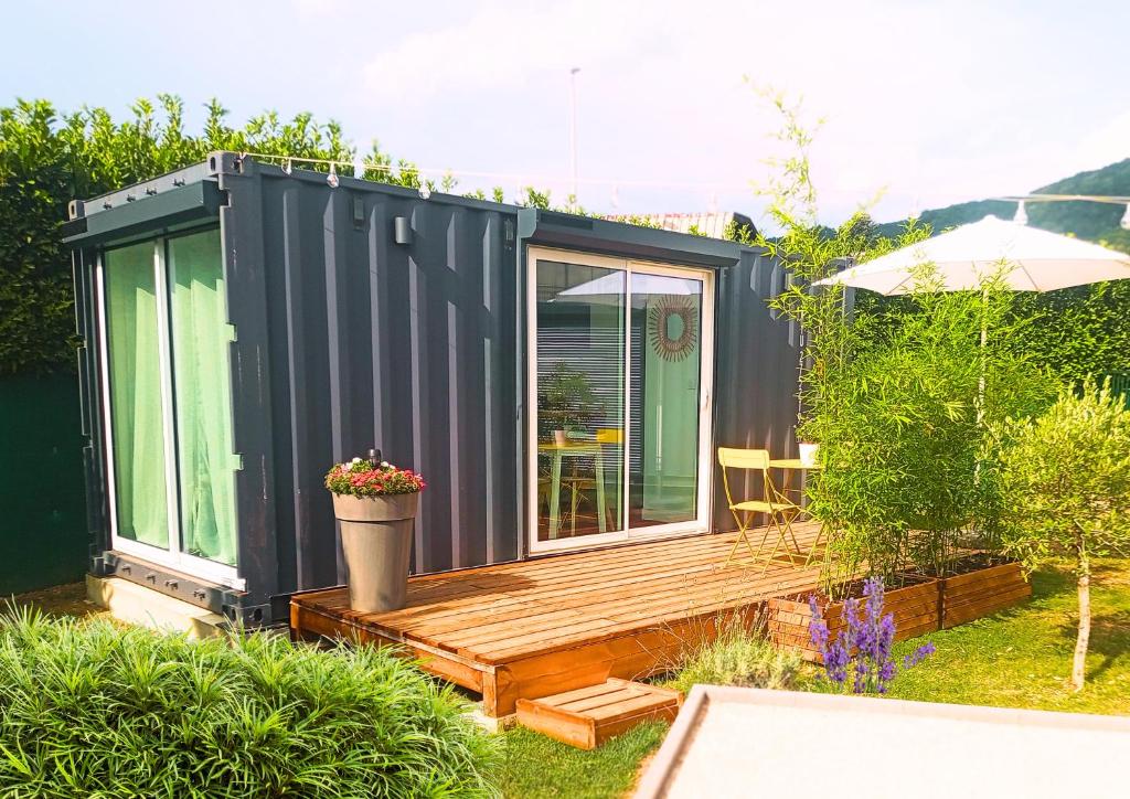 una pequeña casa negra pequeña con terraza de madera en Studio container au look bohème, en Poisat