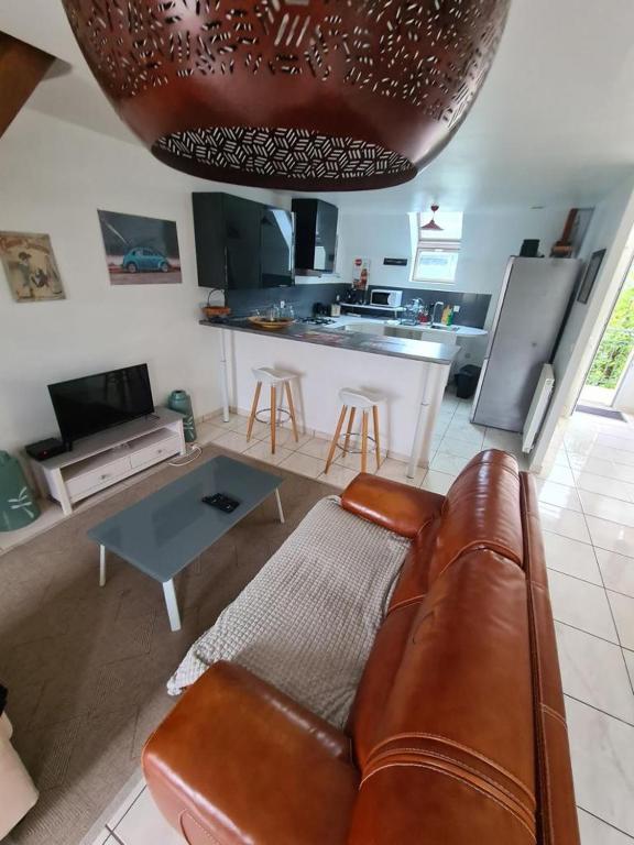 un salon avec un canapé en cuir et une cuisine dans l'établissement Schumann Balcon Vannes, à Vannes