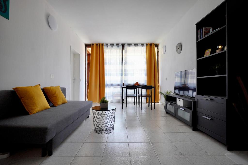 ein Wohnzimmer mit einem Sofa und einem TV in der Unterkunft Apartamento El Gato in Costa Del Silencio