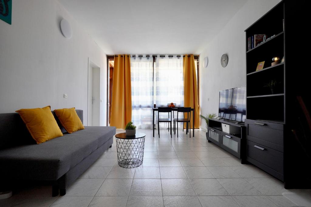 salon z kanapą i telewizorem w obiekcie Apartamento El Gato w mieście Costa Del Silencio