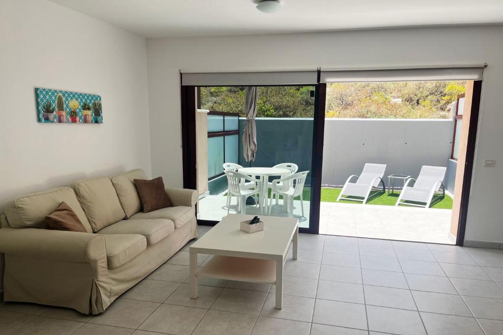 Home2Book Casita Frontera Wonderful Terrace في فرونتيرا: غرفة معيشة مع أريكة وطاولة