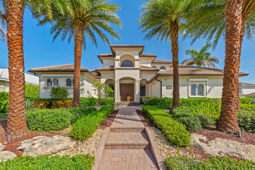 a house with palm trees in front of it at Marco Island's Delight in Marco Island