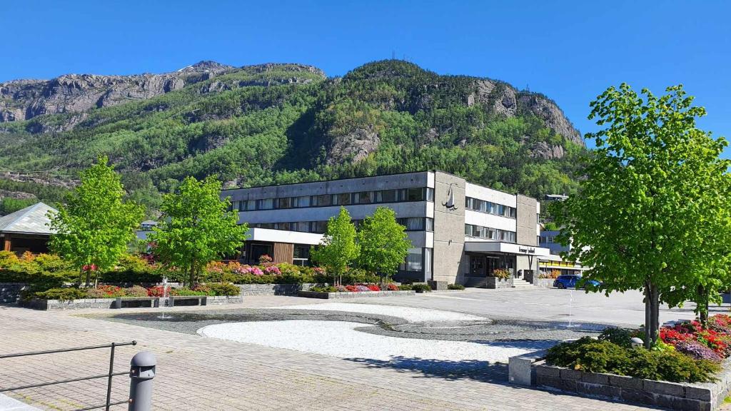 a large building with a mountain in the background at Bremanger Fjord Hotell in Svelgen