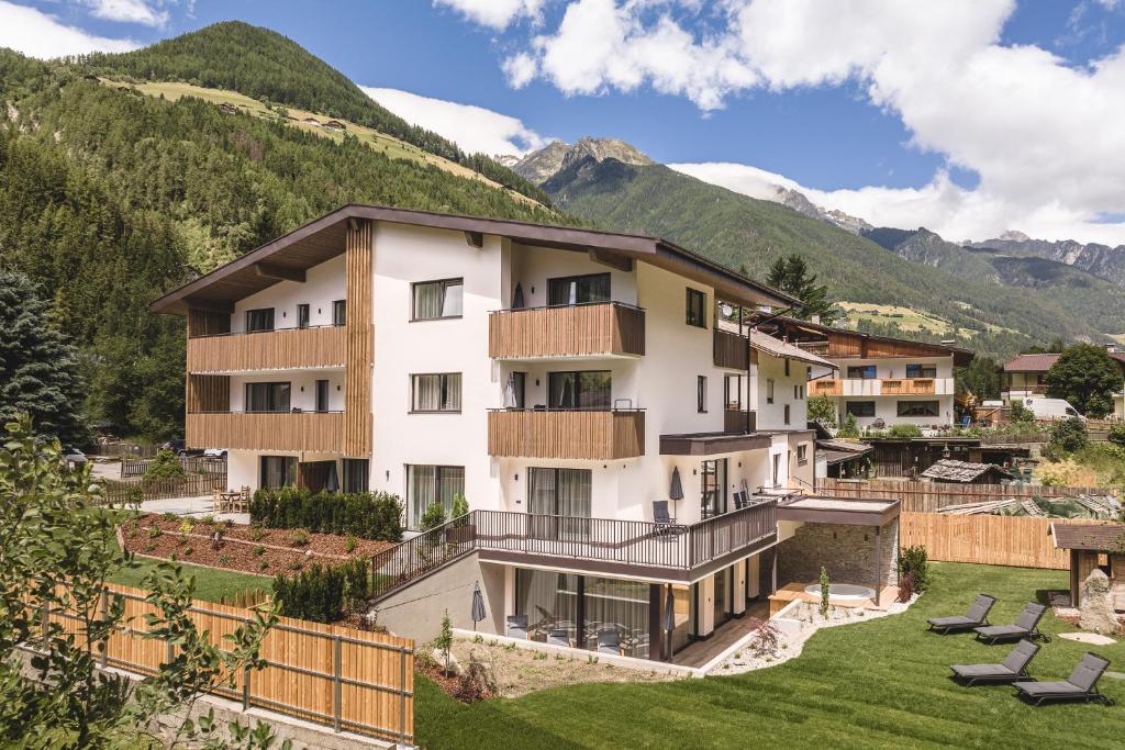 an image of a building with mountains in the background at Apartments Silva Timeout in San Giovanni in Val Aurina