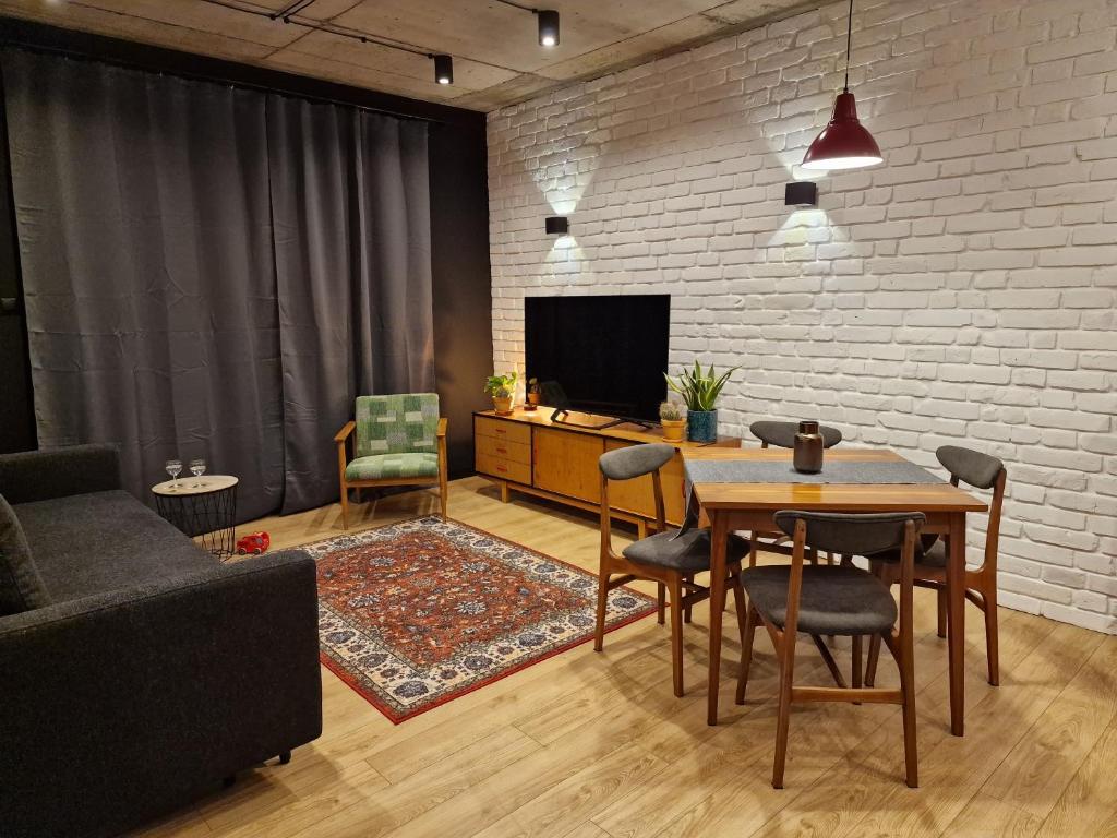 a living room with a table and a tv at Apartamenty LOFTykocin in Tykocin