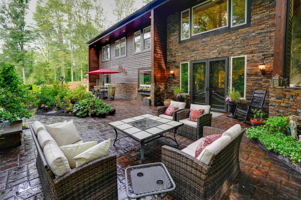 a patio with couches and a table in front of a house at Large Family Home with Patios, Gas Grill and Fire Pit! in Delaware