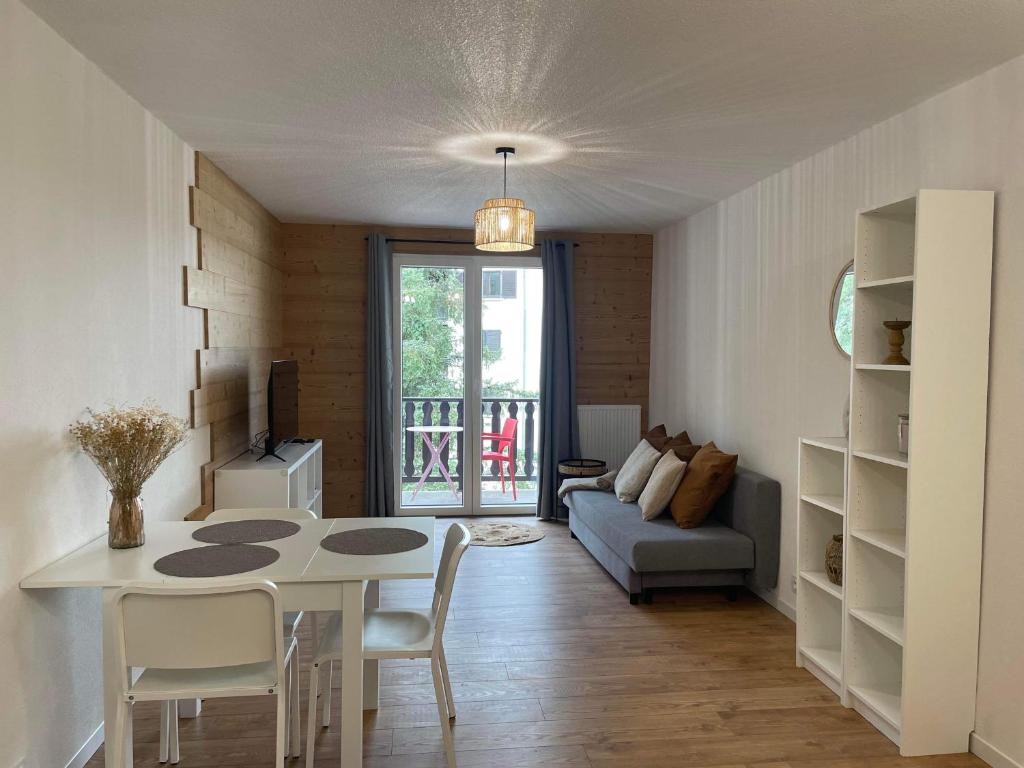 a living room with a table and a couch at Appartement cosy in Métabief