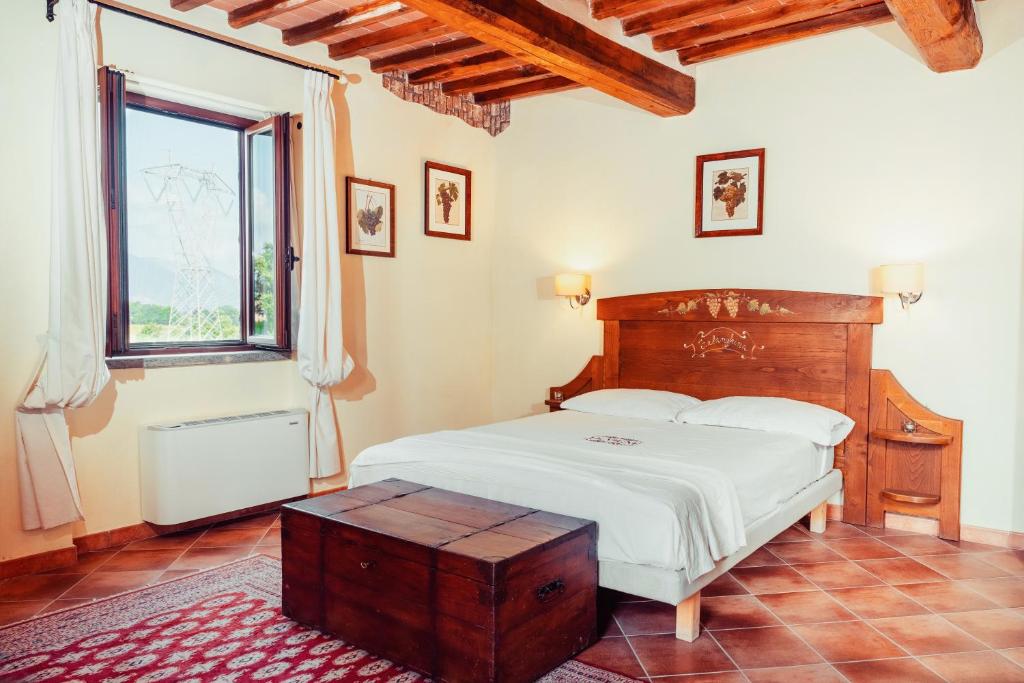 una camera con letto con testiera in legno e finestra di COUNTRY HOUSE LE VIGNE b&b a Galluccio