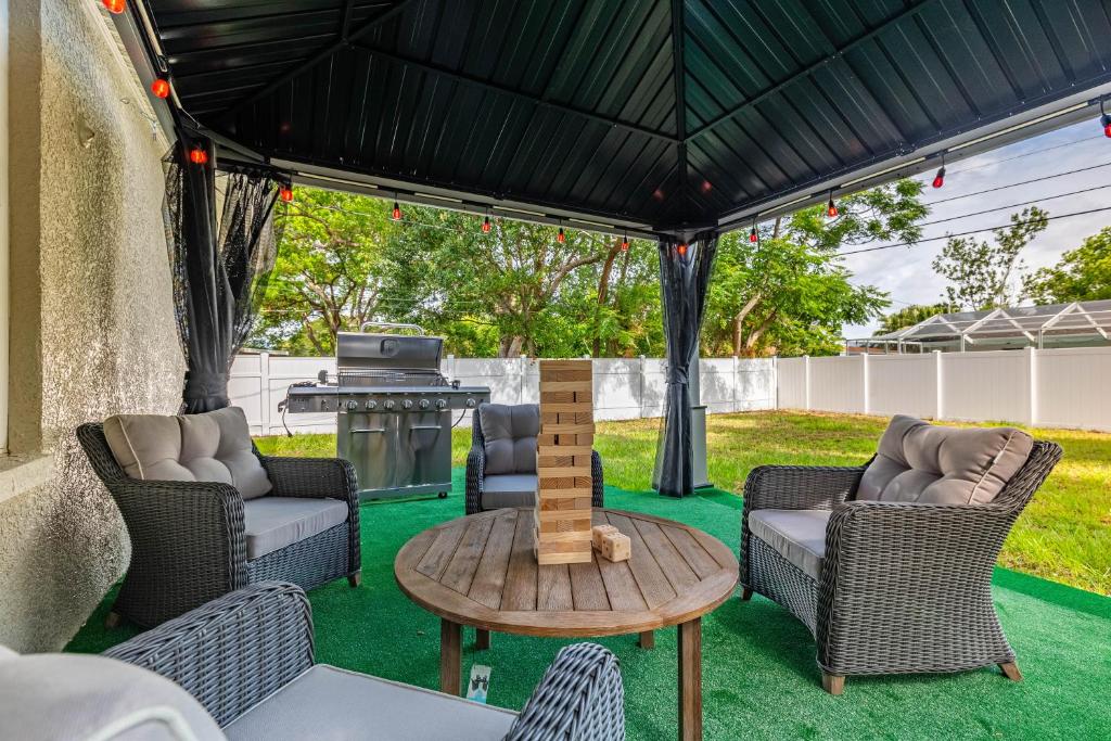 a patio with a table and chairs and a grill at Villa Florentina. in Clearwater