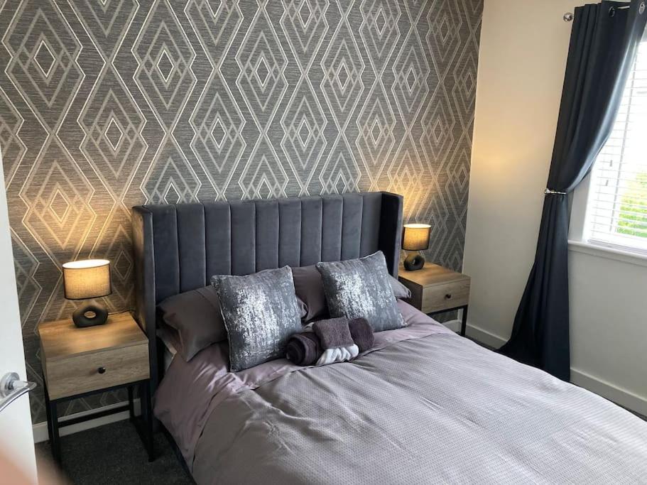 a bedroom with a bed with two night stands and two lamps at Haymons Cove in Eyemouth