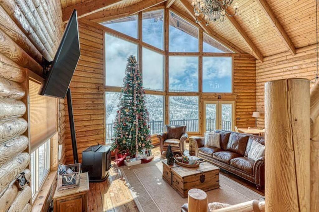 a living room with a christmas tree and a couch at Spectacular Chalet overlooking the ski slopes in Brian Head