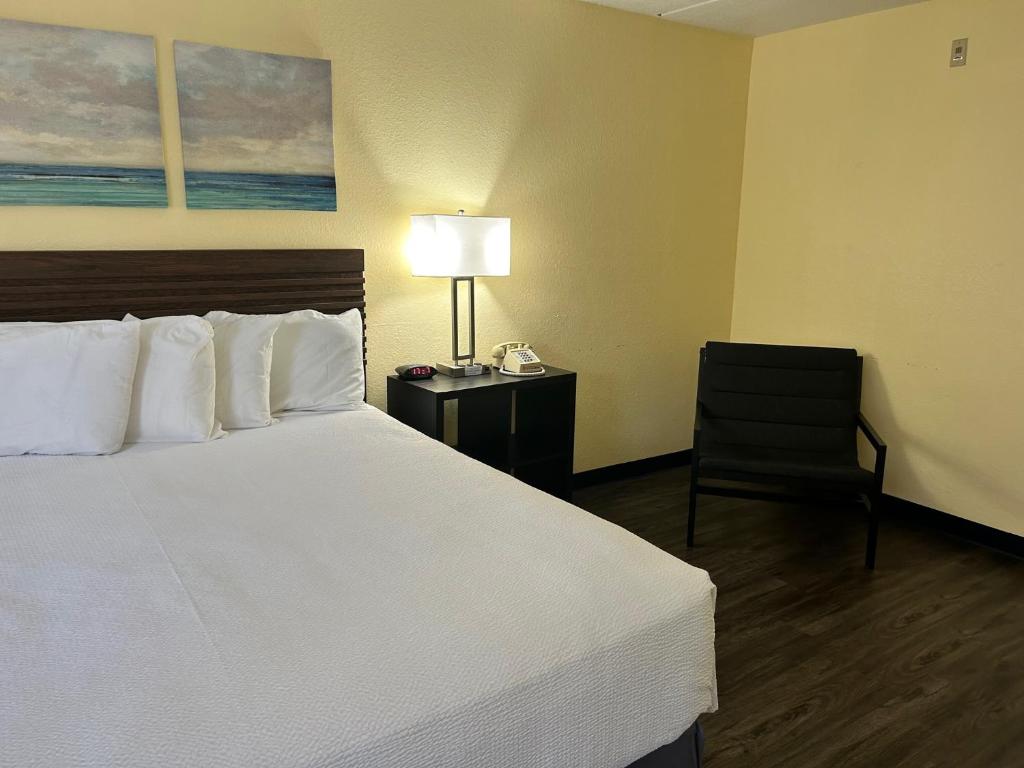 a hotel room with a bed and a chair at Seven Gables Inn in Branson