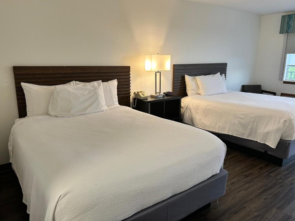 a hotel room with two beds and a lamp at Seven Gables Inn in Branson