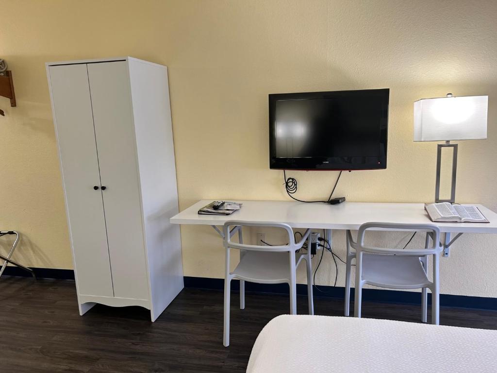 a room with a desk with a computer and a tv at Seven Gables Inn in Branson