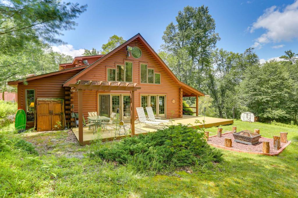 a log cabin with a deck and a patio at Milanville Cabin with Fire Pit, 1 Mi to River! 