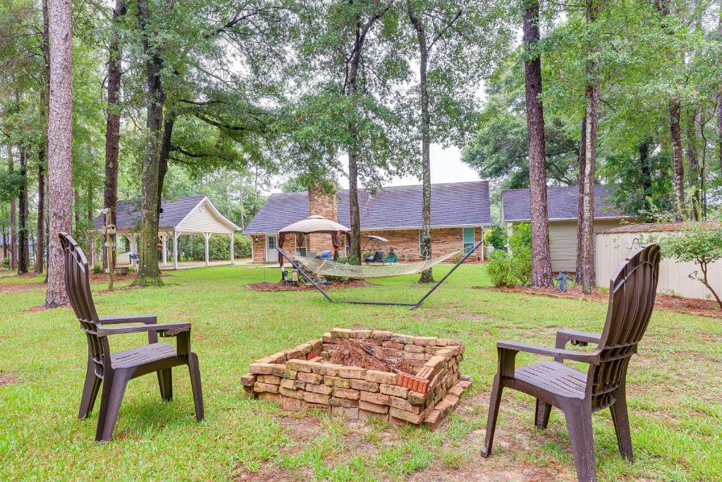 two chairs and a fire pit in a yard at Dog-Friendly Alabama Retreat with Patio and Fire Pit! in Semmes