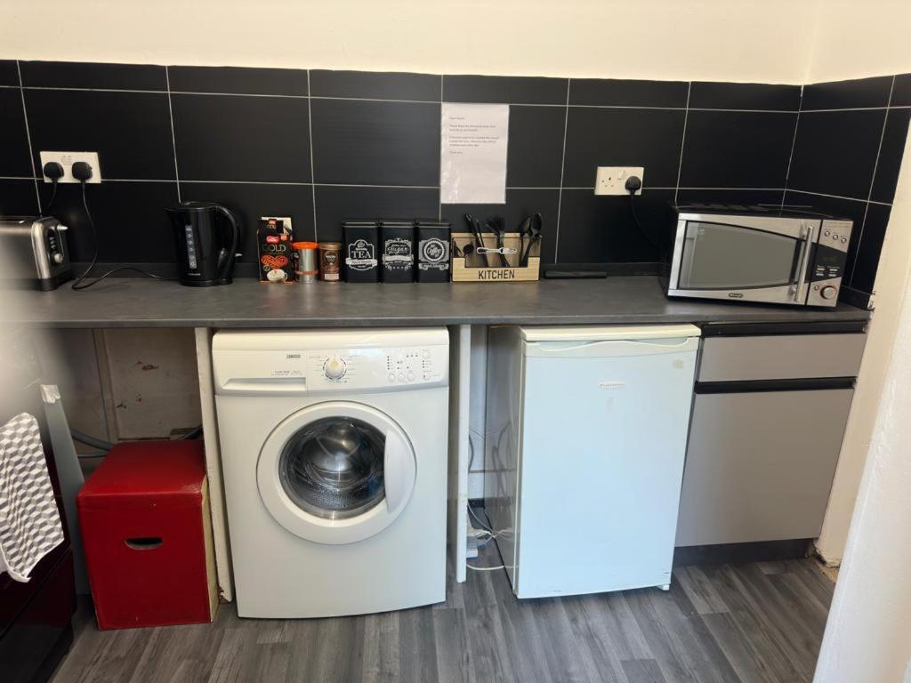 a kitchen with a washing machine under a counter at Central London location, close to bars restaurants and train stations in London