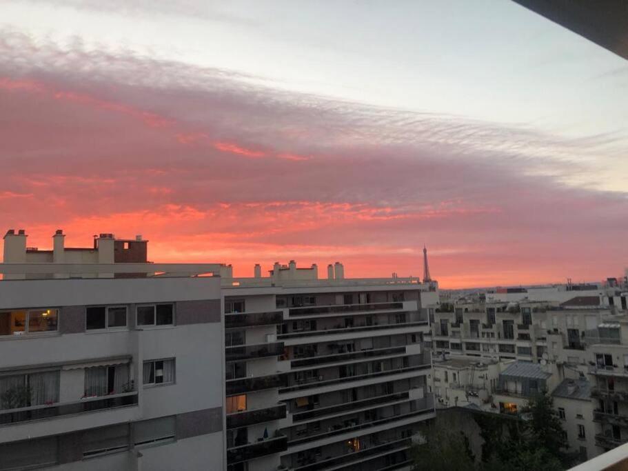 - une vue sur le coucher de soleil d'une ville avec un bâtiment dans l'établissement Nice loft with romantic view over the Eiffel tower, à Paris