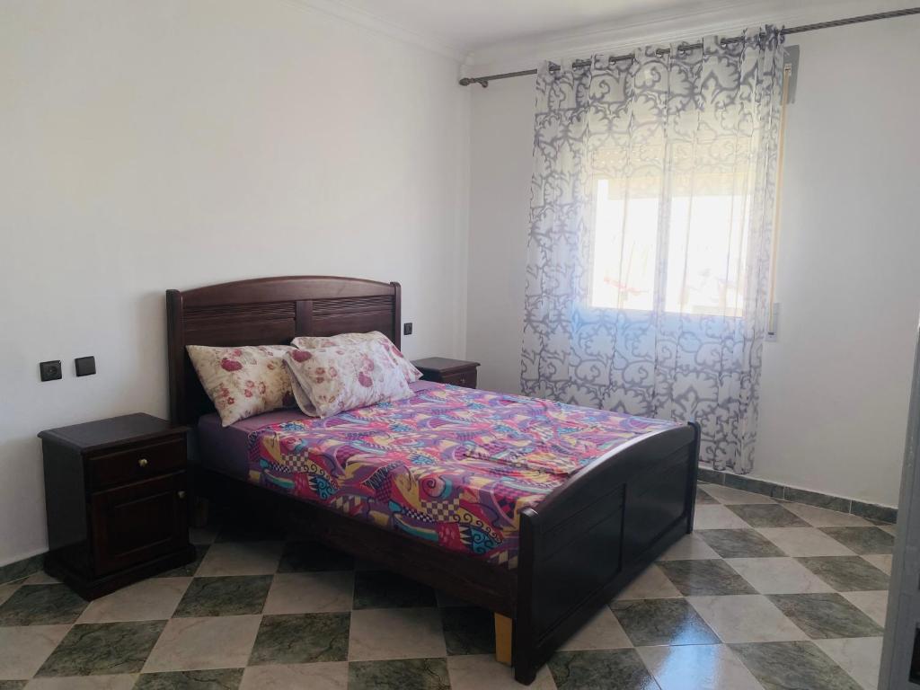 a bedroom with a bed and a window at Paloma Nord in Oued Laou
