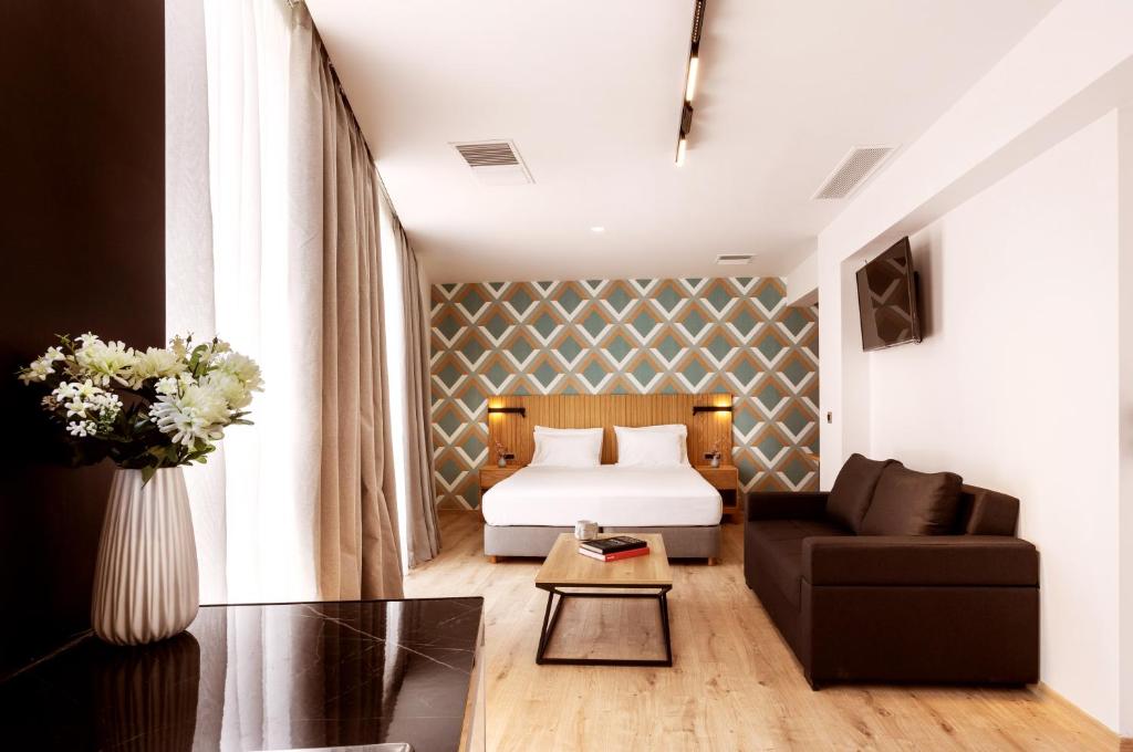 アテネにあるDAYS City Suites Athensのベッドとソファ付きのホテルルーム