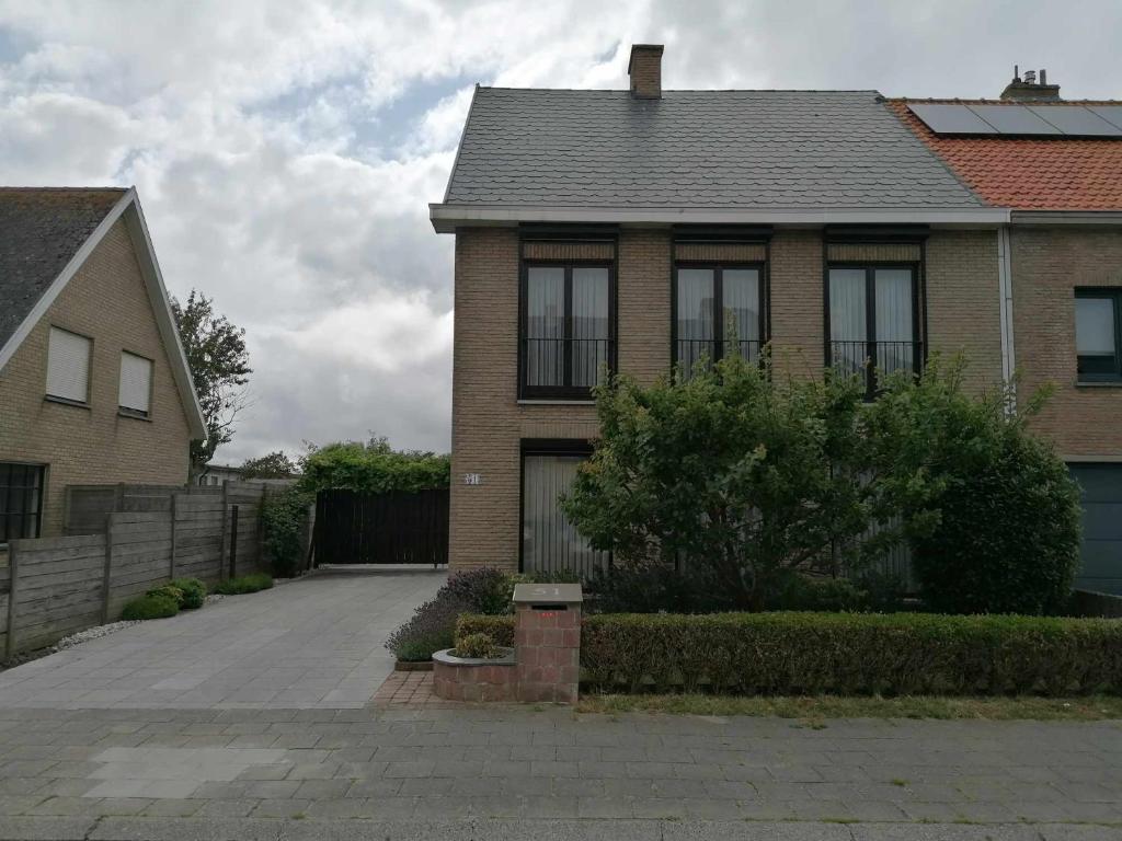 una casa de ladrillo con una entrada delante de ella en Huis Rochelle, en Bredene