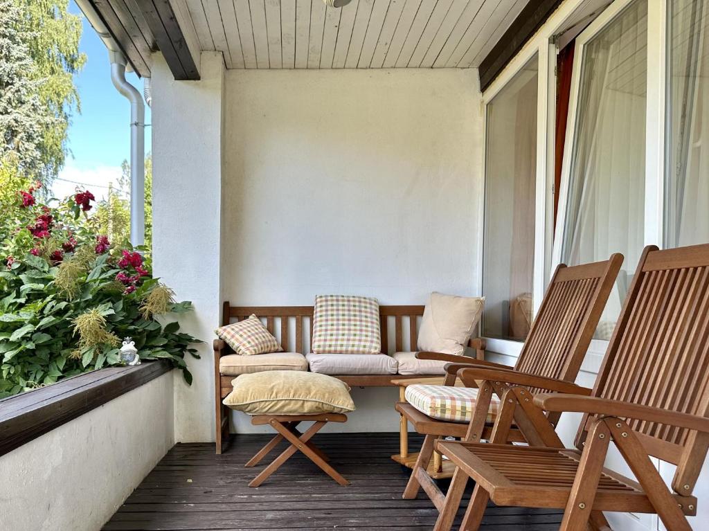 a porch with two chairs and a couch at Guest house Saulkrasti in Saulkrasti