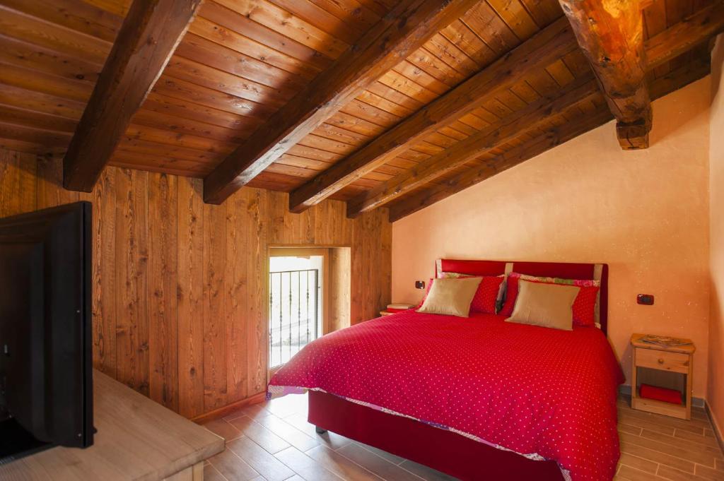 ラ・サルにあるEmilio Apartmentsのベッドルーム(赤いベッド1台、薄型テレビ付)