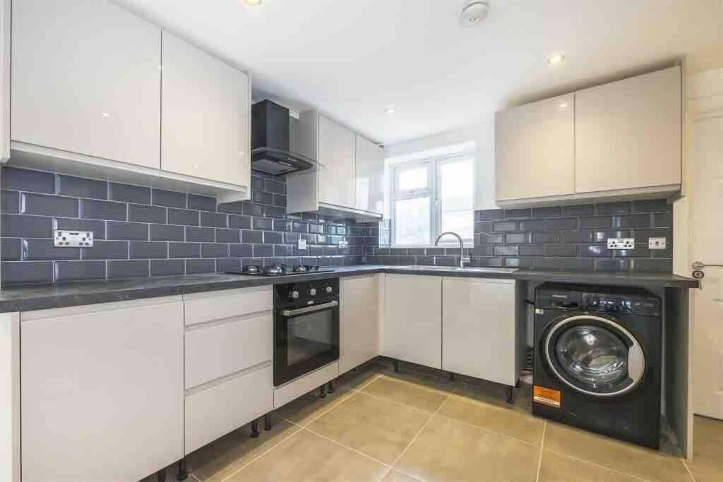 a kitchen with a washer and a washing machine at 30A Mortlake in London