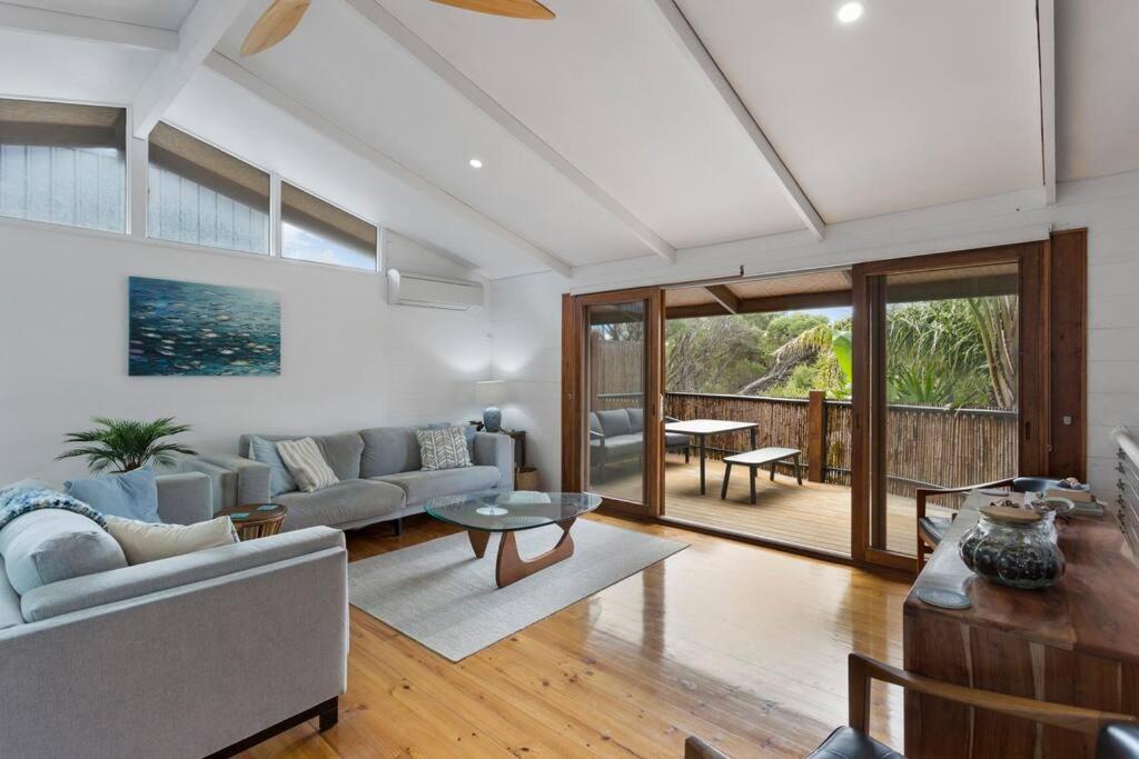 ein Wohnzimmer mit einem Sofa und einem Tisch in der Unterkunft Private & Exotic Island Home Close to Beach Access in Cape Woolamai